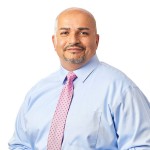 Man in pink tie smiles