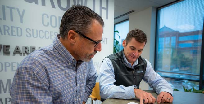 Two men have a conversation at a table