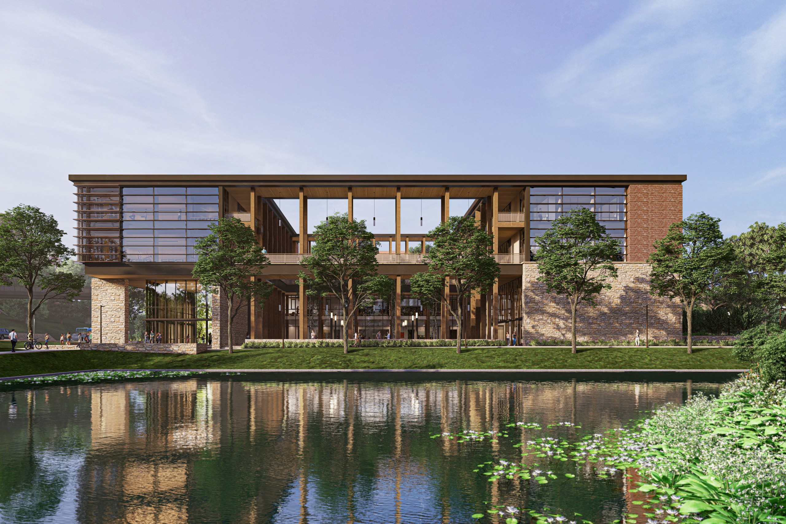 Image depicts a modern black metal building with wooden beams and windows. There is a body of water and plants in the foreground.