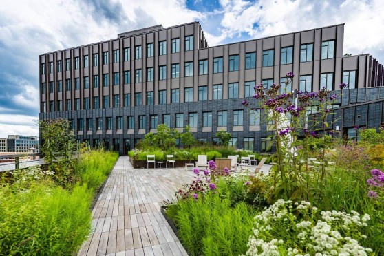 A rooftop building with a stone and metal building in the background.