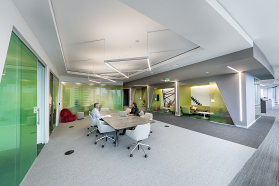 Modern office shows a meeting room with private work spaces on the perimeter.