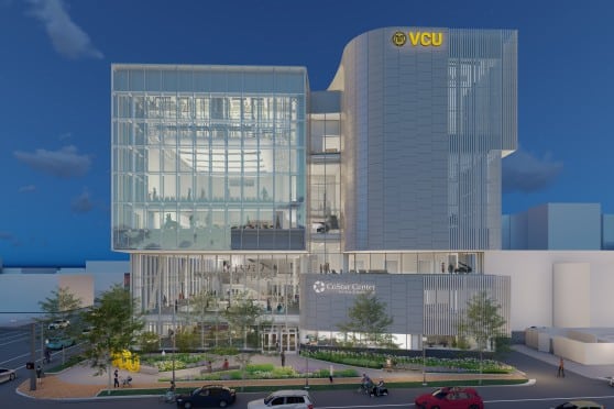 Image depicts a digital rendering of a large modern building constructed of steel and glass. The building has a large square glass portion on the left side.