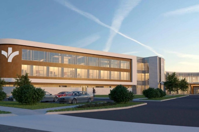 The image depicts a rendering of a of a modern building. The building has lots of windows and wood accents. The building has curved corners, a logo on the far-left section. In front of the building is a parking lot with a few cars and a sidewalk with foliage and pedestrians.