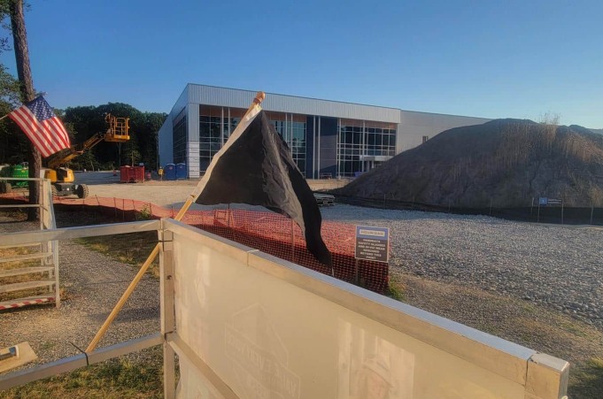 A black pennant flag in front of a construction site.